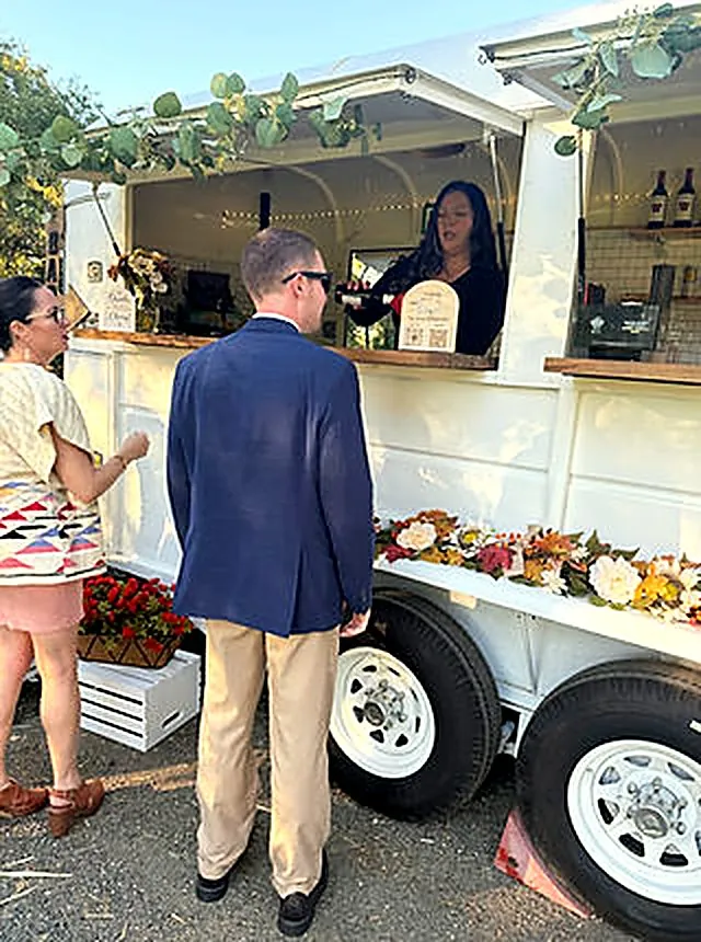 Guests ordering from a bartender at the trailer
