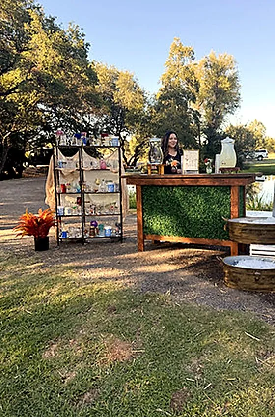 Wood-panel bar with a greenery front set up outdoors
