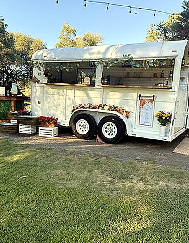 The Saddle Up horse-trailer bar under string lights